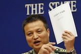 Chinese defence ministry spokesman Yang Yujun holds a copy of Beijing's white defence paper