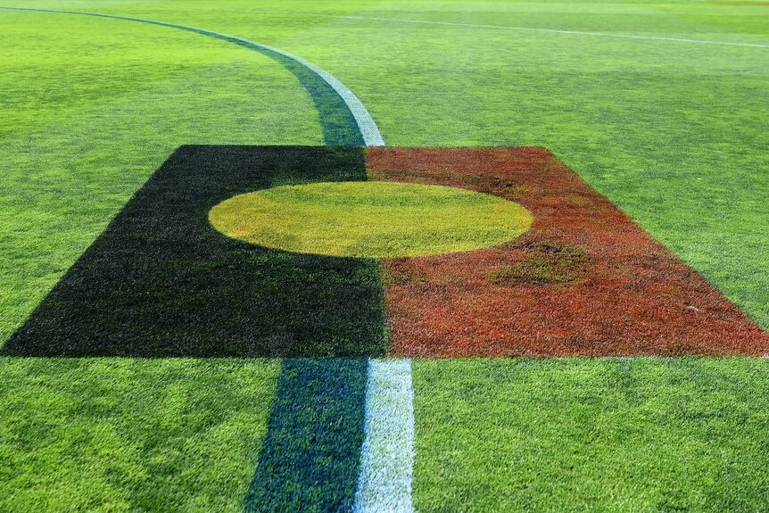 The Indigenous flag is pictured painted onto the 50m arc at an AFLW match