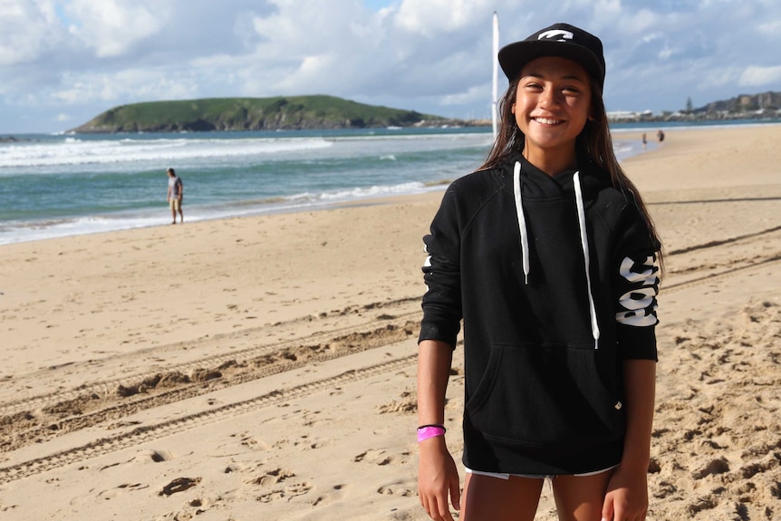 A young girl standing on the beach