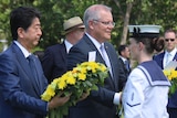 The pair hold wreaths in a park