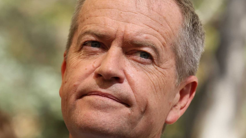 Bill Shorten leans back in his seat as he listens.