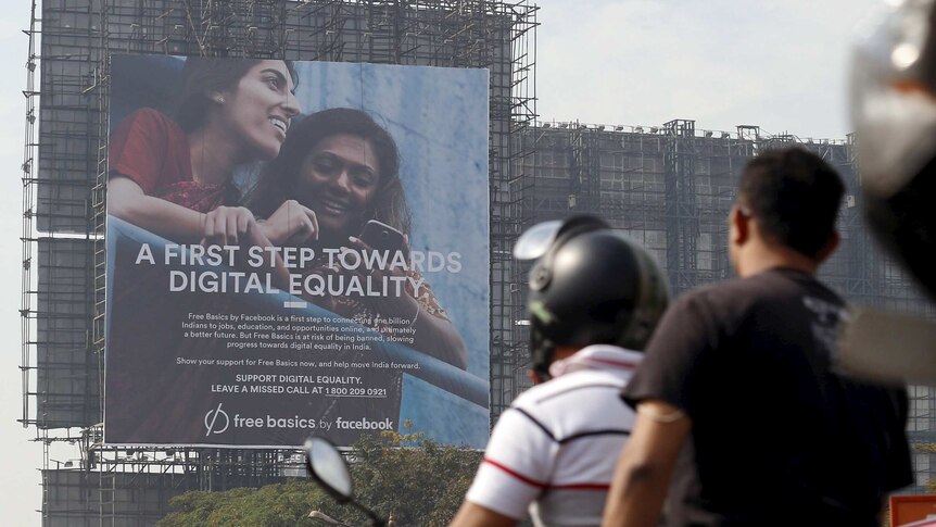 Motorists ride past a billboard displaying Facebook's Free Basics initiative in Mumbai.