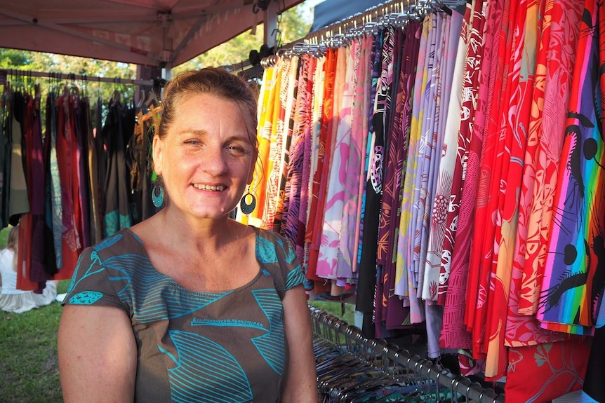 Kathy Gardenal from Injalak Arts in her stall of bright coloured fabrics.