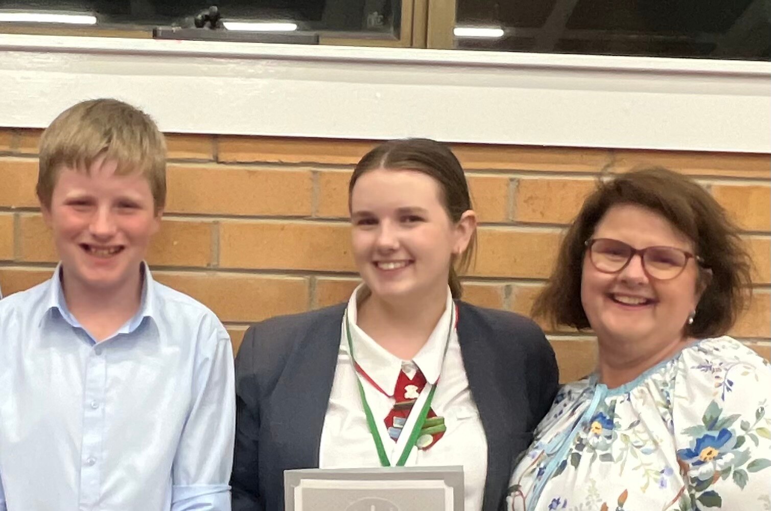 Kathy Claxton smiling and standing next to her two children.