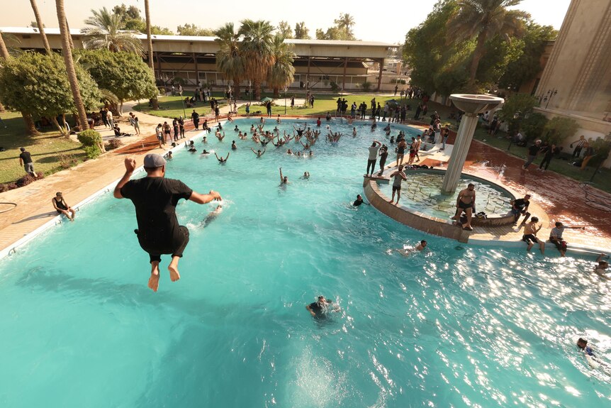 A man jumps into a pool at the government palace in Iraq.