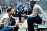 Two prisoners talk in a prison yard.