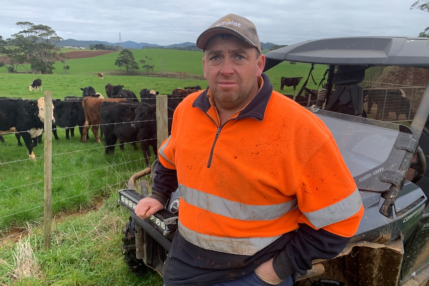 A farmer stands in front of his buggy.