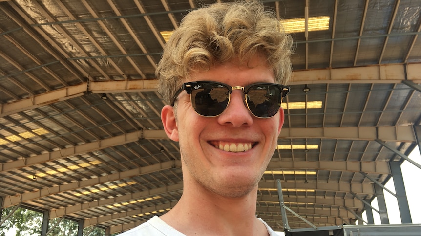 a young man with blonde hair and sunglasses