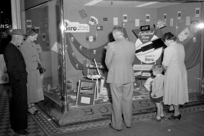 People inspect a display of biro pens in Boans window, 1954