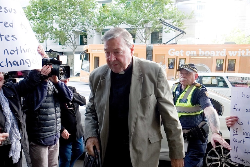 Cardinal George Pell walks into the Melbourne Magistrates' Court.