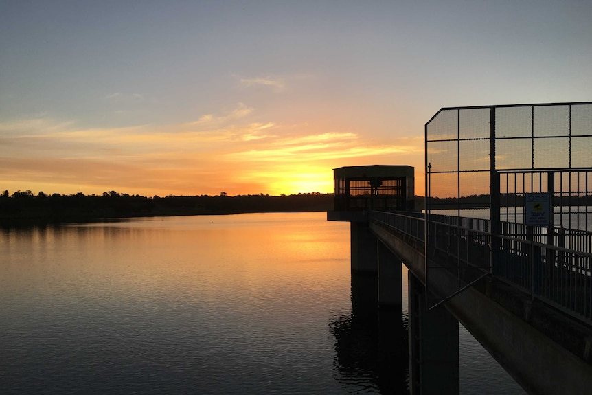 A concrete platform at a dam at sunset