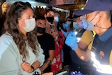 Thai immigration officers talk to people at a bar on Koh Phangan island.