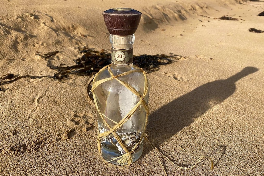 A message in a bottle on a sandy beach