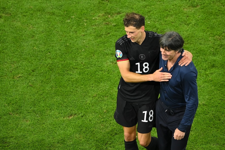 L'entraîneur de football allemand Joachim Löw met son bras autour du buteur Leon Goretzka après la victoire de l'équipe.,