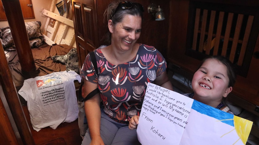 Mother and young daughter in wooden sailing ship destined for Manus Island.