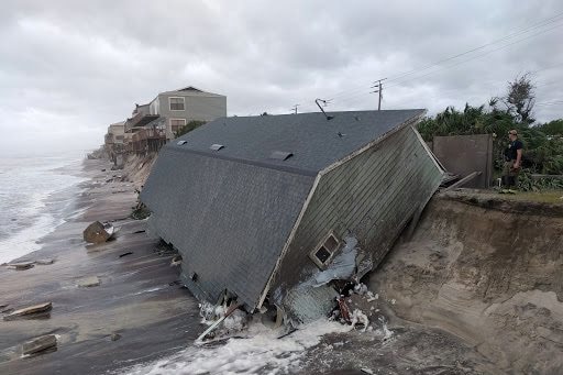 A grey building slides down an eroded hill at Vilano Beach after hurricane irma
