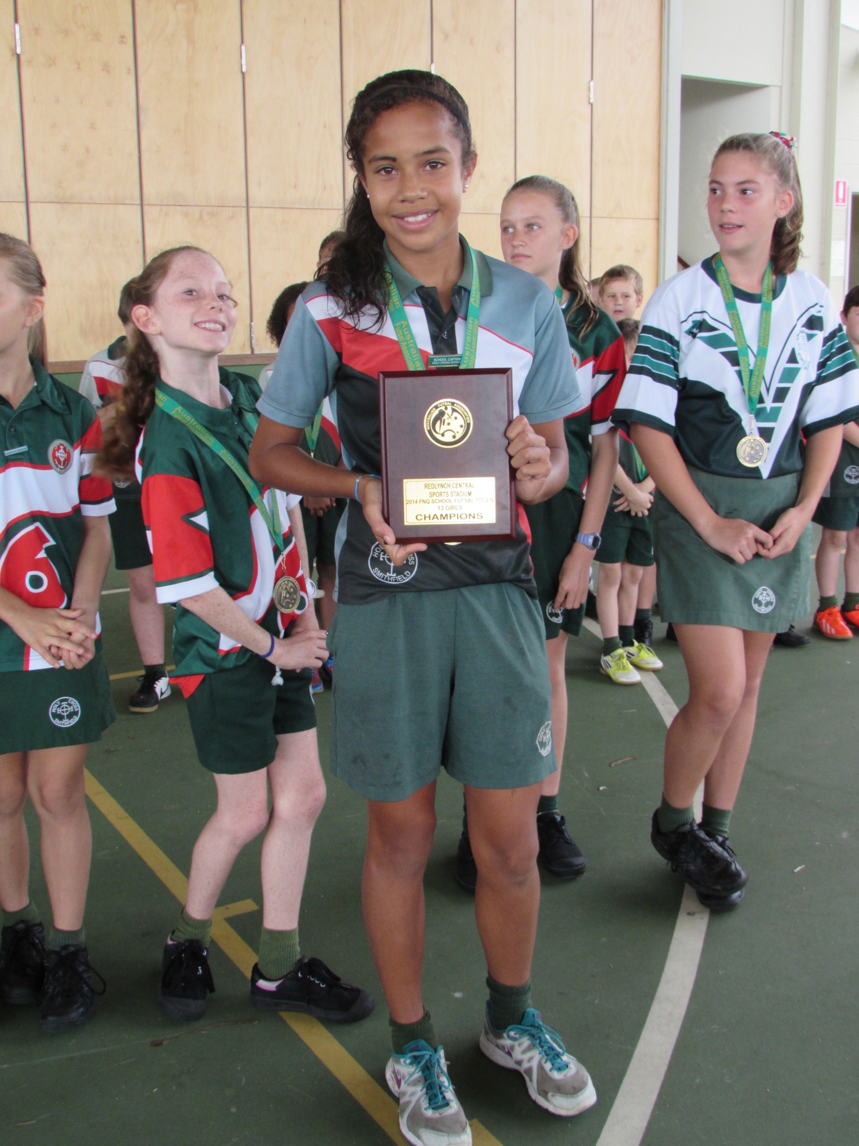 Schoolgirl holding a trophy.