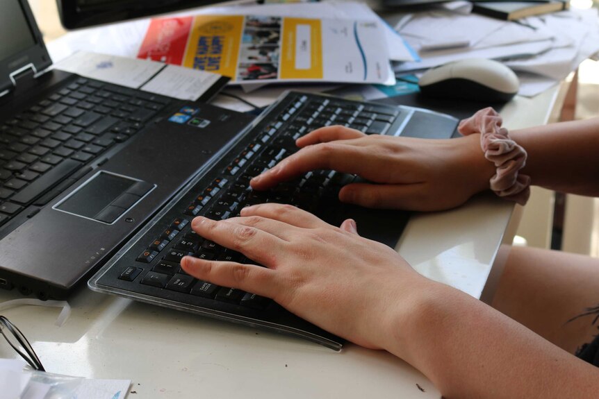 Young woman's hands typing on a keyboard