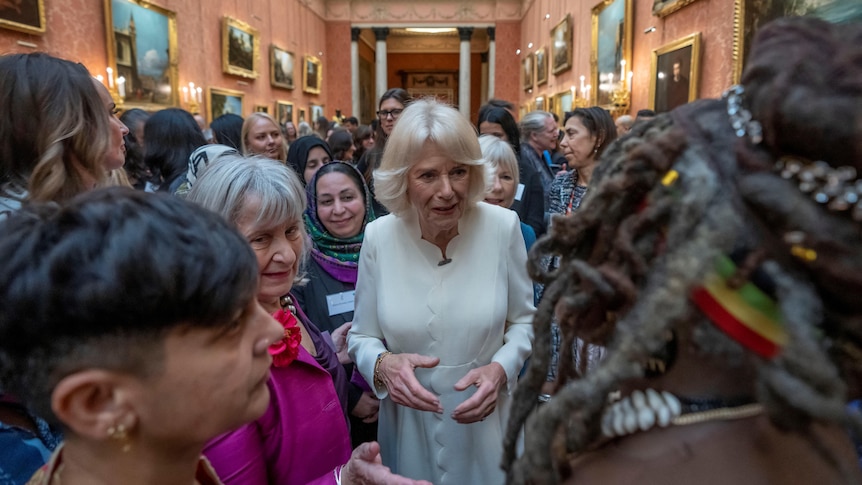 Queen Camilla surrounded by a crowd of women 