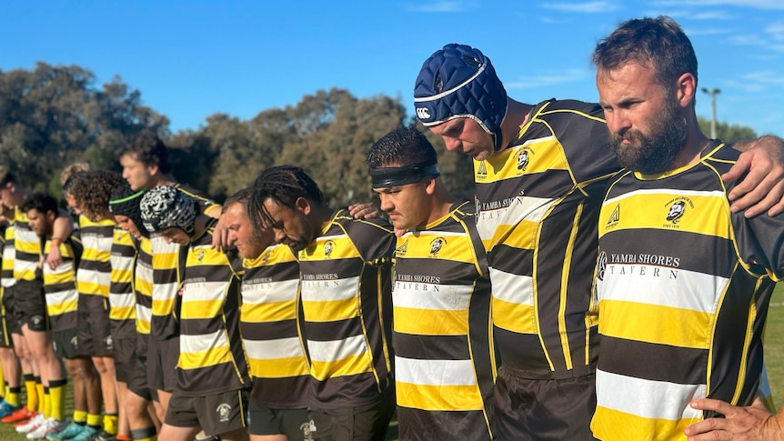 Rugby players stay silent in a row before a match. 