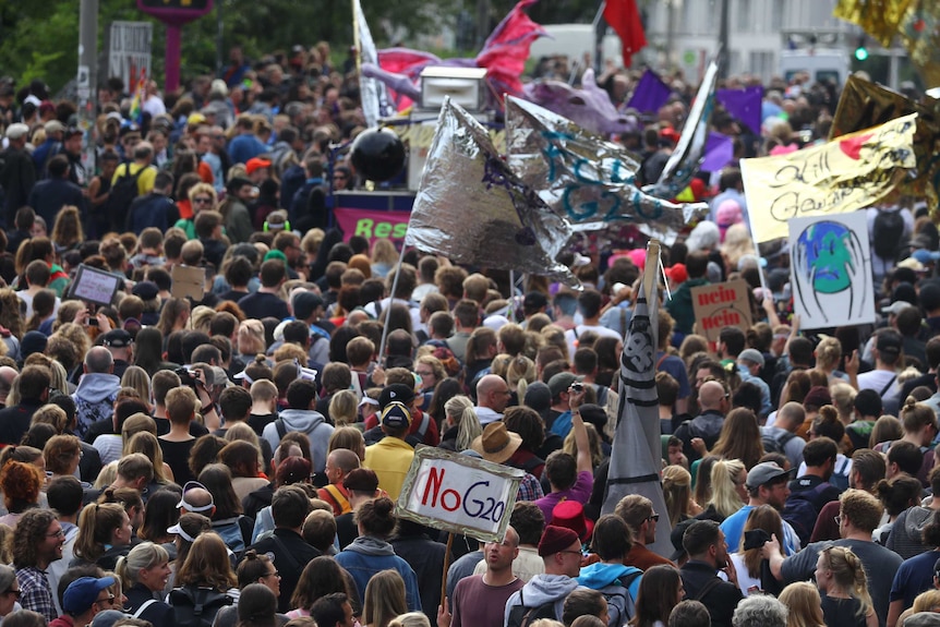 Crowd of people, some with signs saying "No G20"