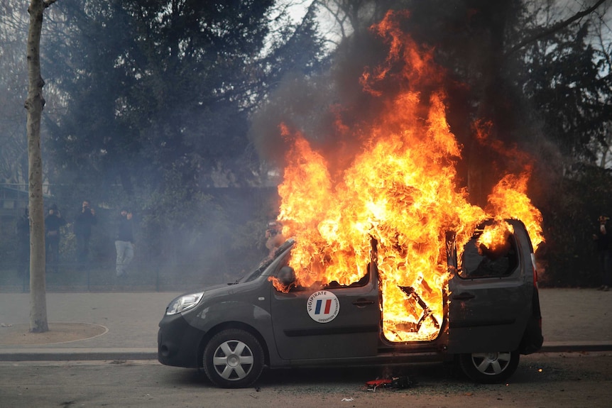 A car is on fire on street in Paris