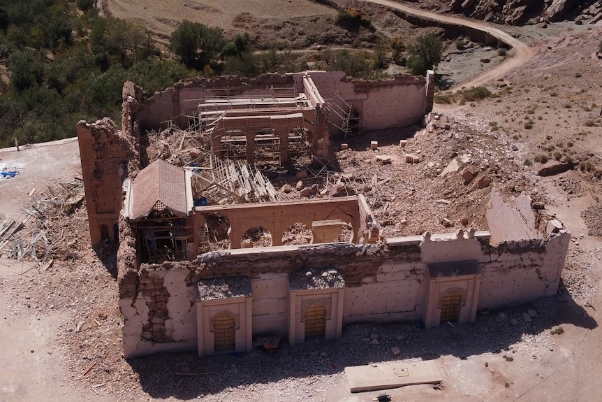 A close up of a damaged mosque surrounded by rubble.