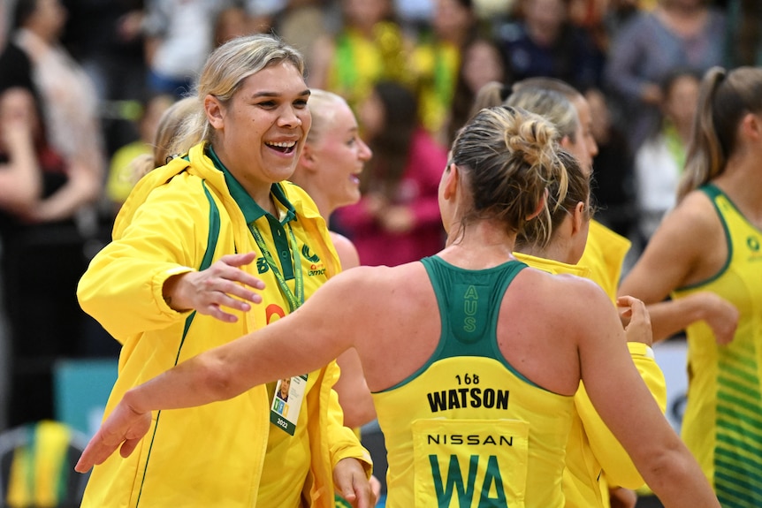 Donnell Wallam wears her Diamonds green and gold tracksuit as she hugs Liz Watson after Game 4