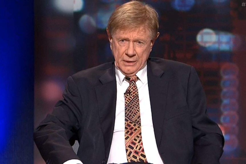 Kerry O'Brien wears a dark suit and white shirt with a tie.