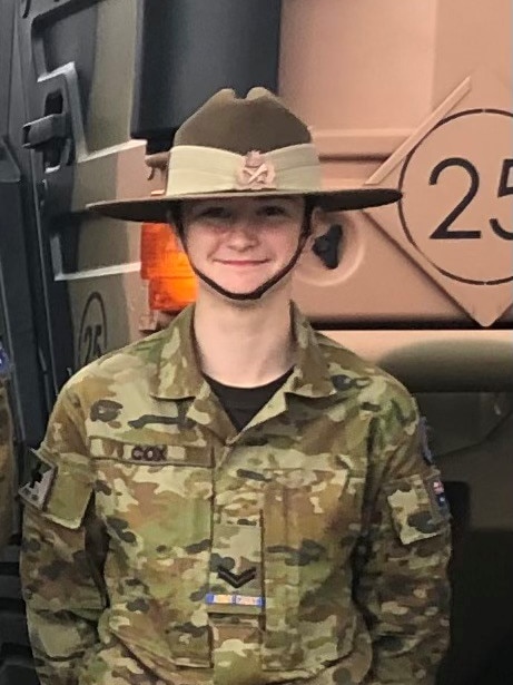 A teenage girl in an army-style uniform with a wide brimmed hat.