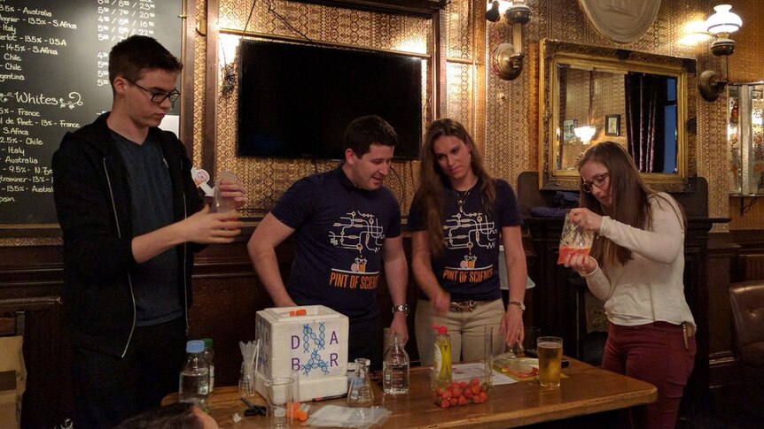 Group in a pub doing a science experiment.