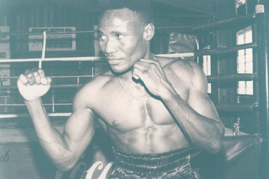 a shirtless black man in a boxing pose