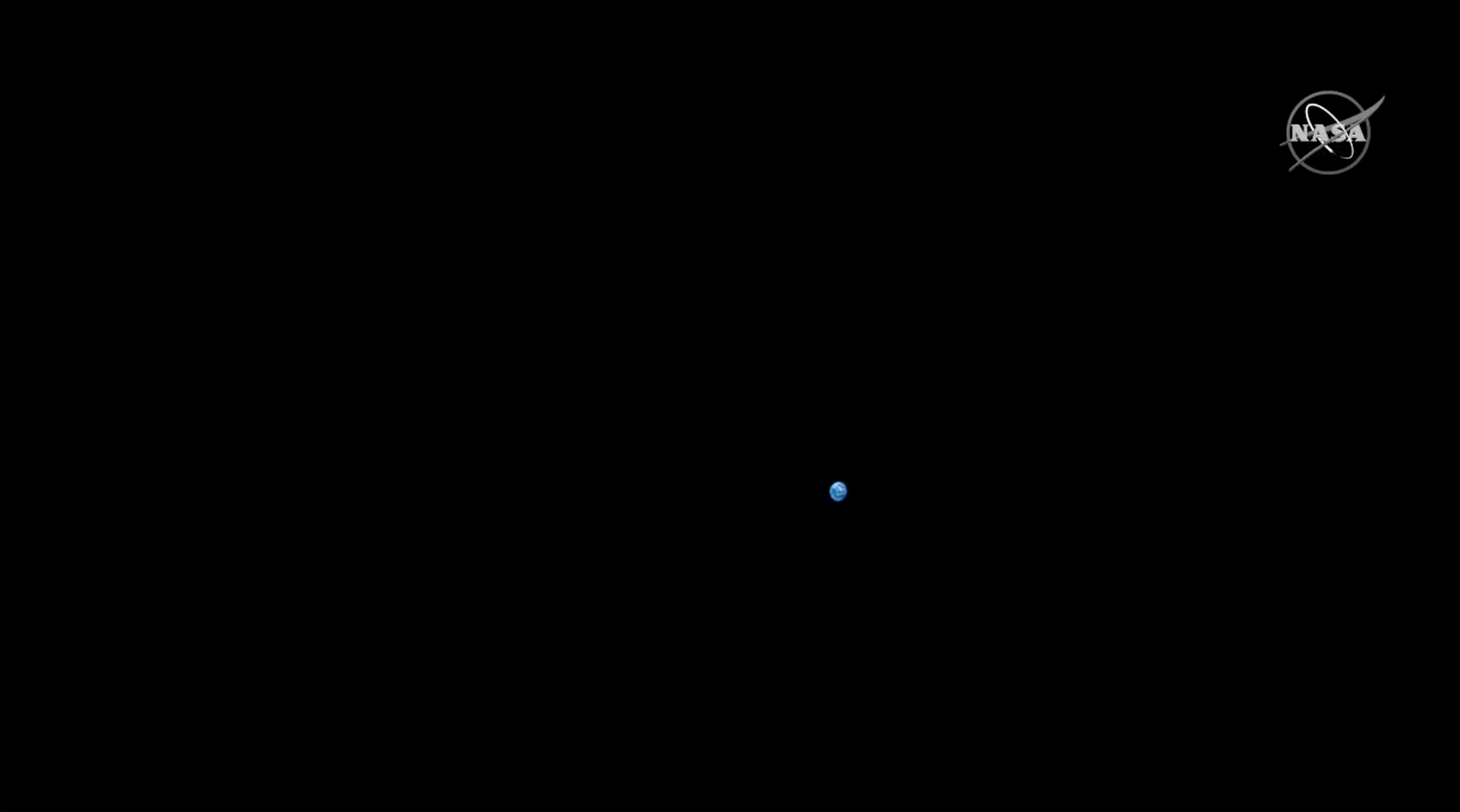 A small blue spec among a black background. 