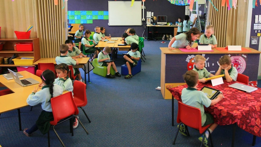 Mount Ousley Public School kindergarten pupils using an iPad in class.