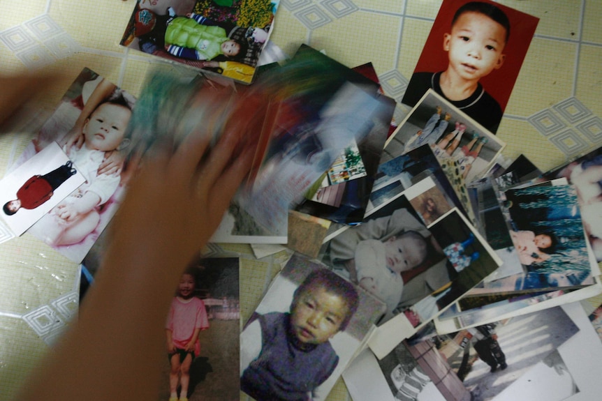Photographs of a number of lost children are seen at the home of a mother in China's southern Guangdong province.