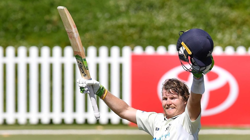 Will Pucovski holds his bat and helmet in the air