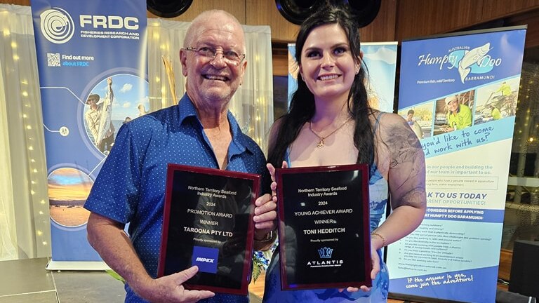 a man and a woman holding awards.