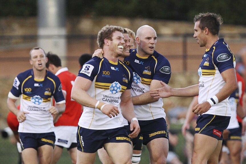 Brumbies players David Pocock (2L) and Clyde Rathbone (C) celebrate a try during a trial match against the ACT XV.