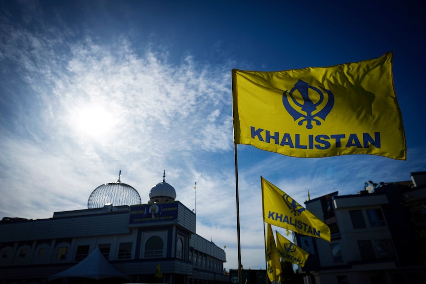 A yellow flag reading: "Khalistan" in front of temple. 