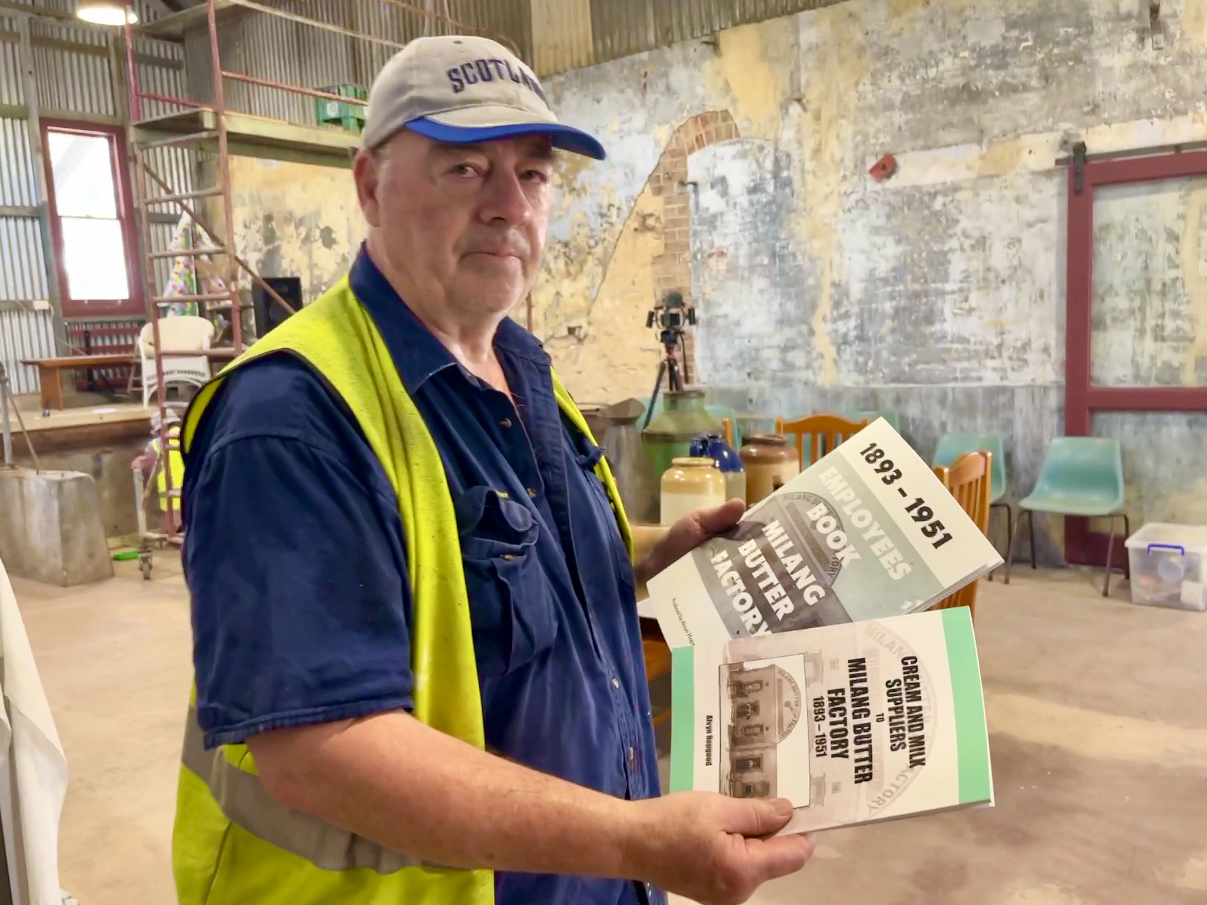A man displays books written about the employees and suppliers of the Milang Riverside Butter Factory