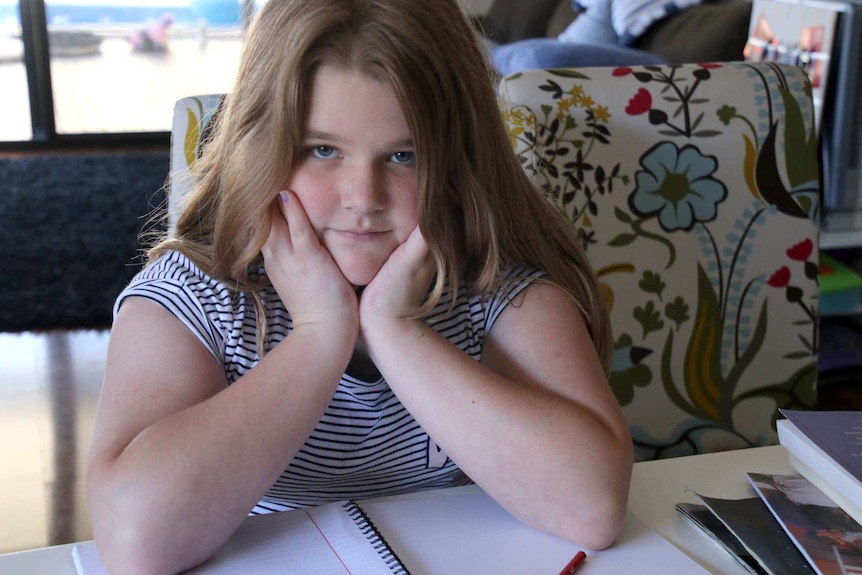 Charlotte Dainton smiles slightly with her chin cupped in her hands.