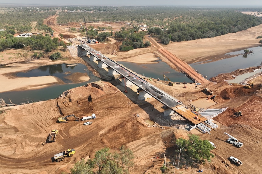 An aerial shot of a new bridge with construction equipment on it