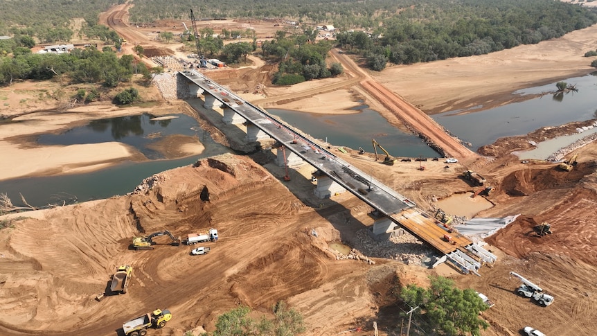 An aerial shot of a new bridge with construction equipment on it