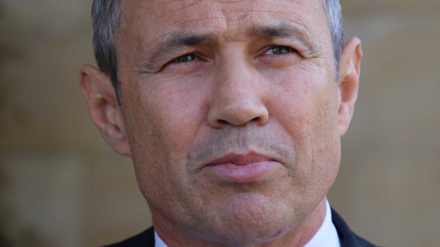 Close up of Roger Cook with his lips together and looking into middle distance.