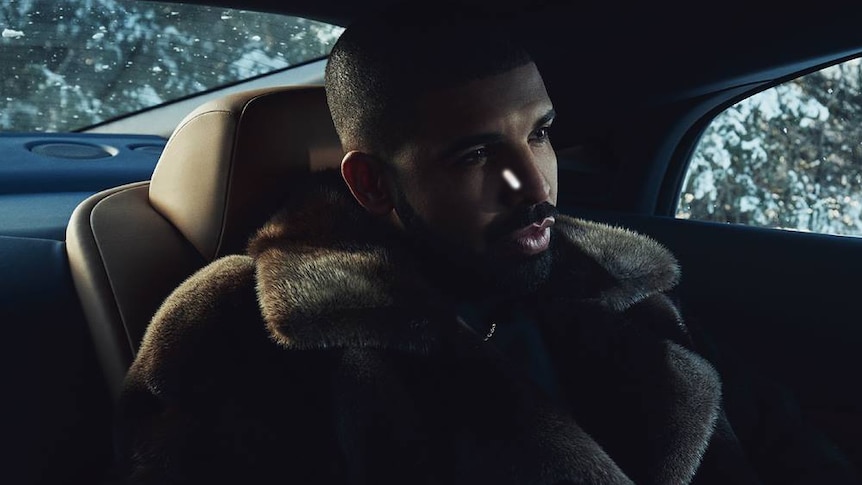 A 2017 press shot of Drake rugged up and riding inside a luxury automobile