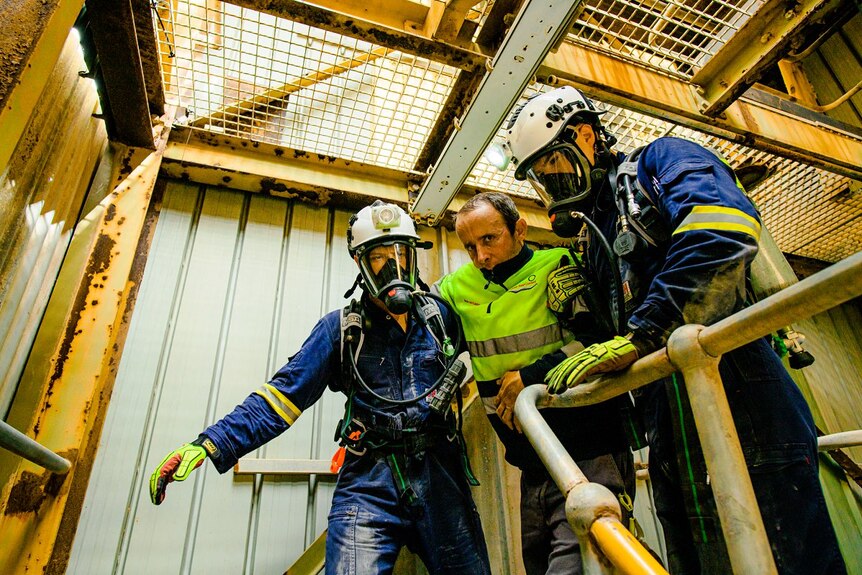 two mine rescuers carry a miner in a simulation exercise