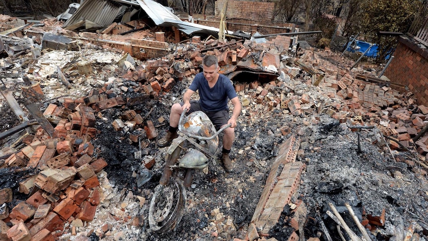 Paul Bousfield sits on the remains of his Suzuki VL 800 motorbike.