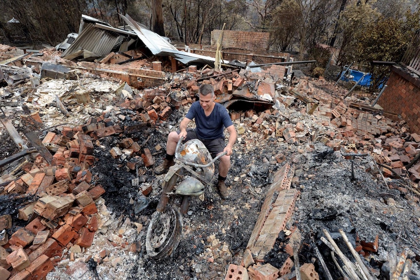 Paul Bousfield sits on the remains of his Suzuki VL 800 motorbike.