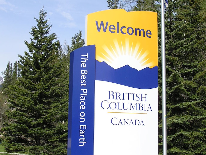 A sign in a North American forest that reads "Welcome British Columbia Canada, The Best Place on Earth'"