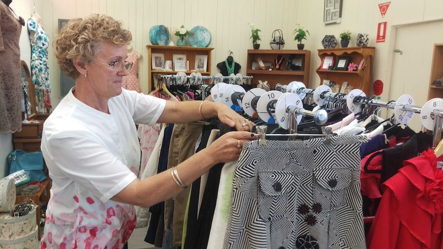 The local postmaster Diane Mill browses through pre-loved garments at the Ilfracombe post office.